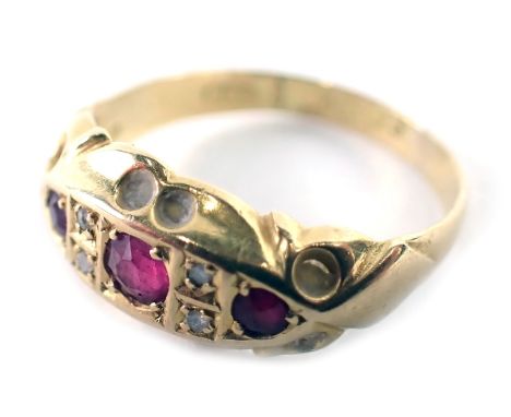 An 18ct gold ruby and diamond gypsy ring, the boat shaped ring head set with three round brilliant cut rubies and four round 