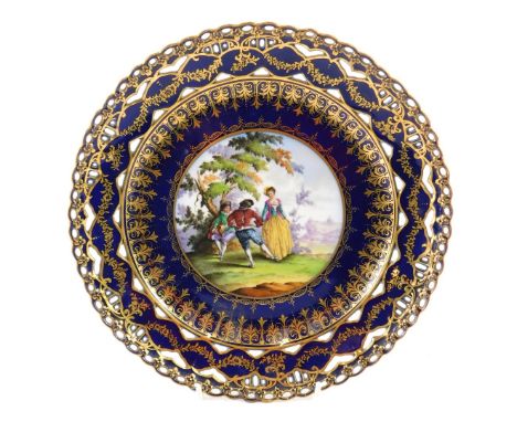 A Dresden porcelain plate, painted with figures, in 18thC scene within cobalt blue in gilt pierced borders, hand written Dres