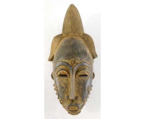A Baule Mblo spiritual portrait mask with elaborate coiffure, Cote D'Ivoire, 38cm high. 