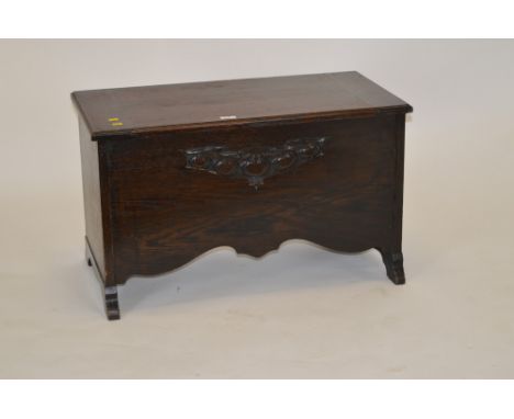 A 20th Century oak blanket box, with hinged rectangular top enclosing an interior, the front with stylised depictions of feet