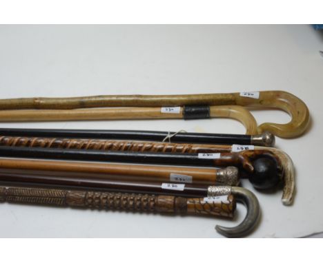 Eight walking sticks, to include: two silver topped canes c1900; a silver mounted stick with horn handle; two ewe horn crooks