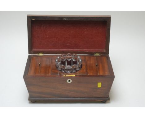 An early Victorian mahogany tea caddy, raised on bun feet, with fitted interior and glass mixing bowl, 33cms wide.