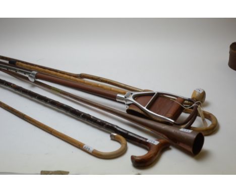 A copper horn; a leather shooting stick; and five walking sticks, one silver capped.