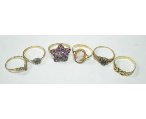An amethyst set ring, in star pattern mount, on yellow metal shank stamped '9k'; a carved shell cameo ring; a buckle pattern 