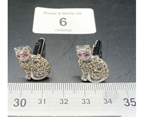 A pair of silver and marcastie cat cufflinks with ruby eyes 
