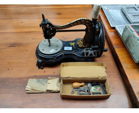 An antique hand Cranked sewing machine by Jones with original leaflet and accessories . 
