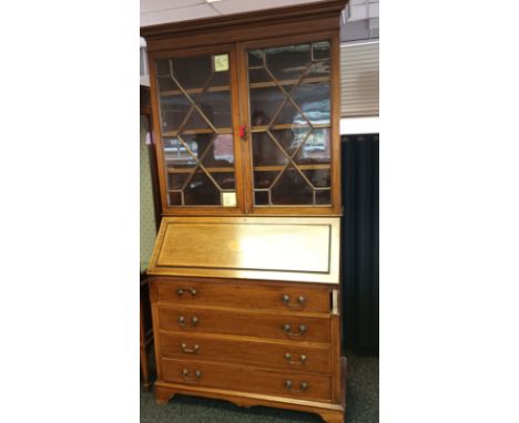 19th century bureau [W.J. Mansell] the moulded cornice above two glass doors with moulded design,leading to three interior sh