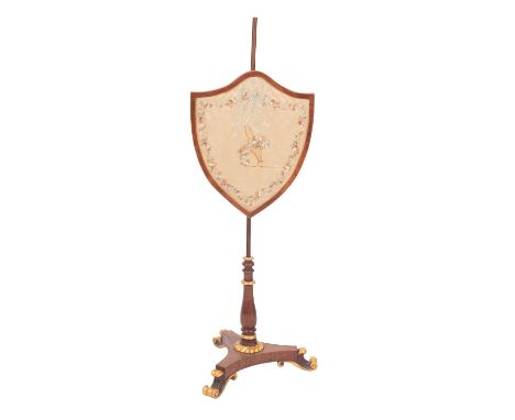 A Regency mahogany and parcel gilt pole screen, early 19th century; with floral embroidery within a height adjustable shield 