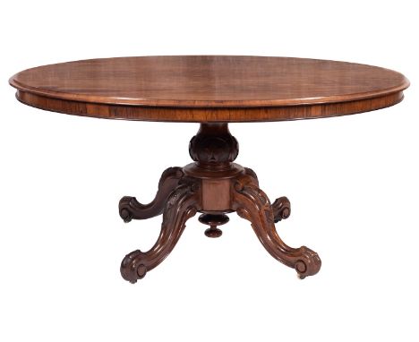 A Victorian rosewood oval centre table, circa 1860; the hinged top with ogee moulded edging on a block with central bullseye 