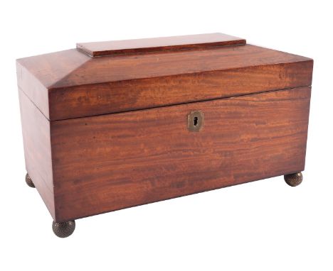 An early Victorian satin mahogany tea caddy, mid 19th century; of sarcophagus form, the hinged cover opening to a fully fitte
