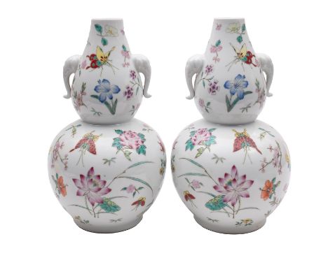 A pair of Chinese porcelain double gourd vases, with elephant mask handles, enamelled in the famille rose palette with flower