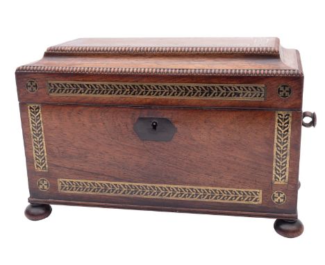 A Regency rosewood and brass inlaid tea caddy, circa 1815; of sarcophagus form, the top with beaded edges opening to a fitted