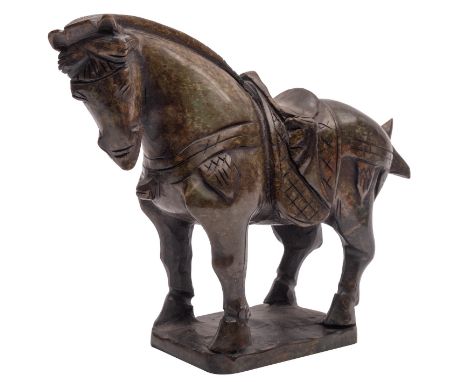 A Chinese carved jade model of a horse standing four-square with saddle and harness, the stone of mottled grey and green colo