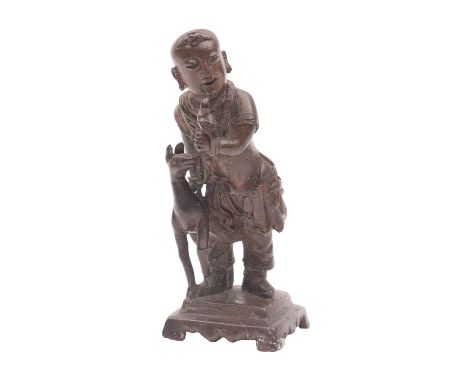 A Chinese bronze figure of a boy holding a parrot, a gourd on his back and a faun at his side, on stepped base, probably 17/1