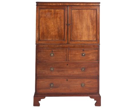 A Regency mahogany press cupboard, circa 1815; of diminutive proportions; the top with reeded edges above twin panel doors op