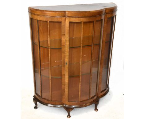 An Art Deco walnut bowfront display cabinet, the single glazed door enclosing two fixed shelves on pad feet, height 121cm, wi