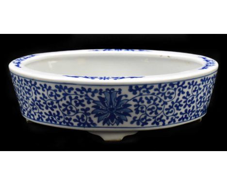 A modern Chinese blue and white ceramic planter of oval form, transfer printed with lotus flowers and scrolling decoration, b