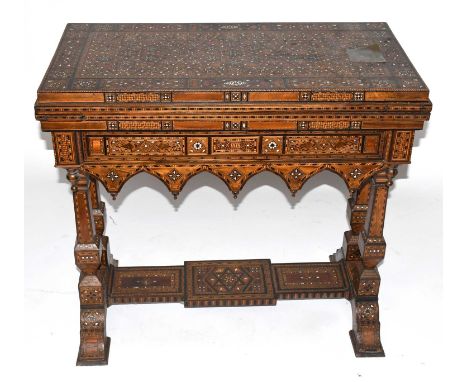 A circa 1900 Moorish profusely inlaid combination games table, the hinged lid enclosing a baized surface for cards, hinged wi