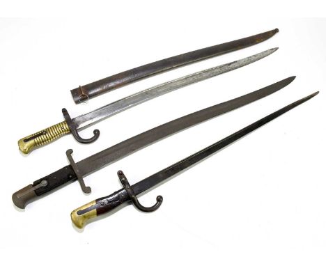 Two French bayonets, one with brass grip and scabbard, the blade back with engraved name and dated June 1872, with a smaller 