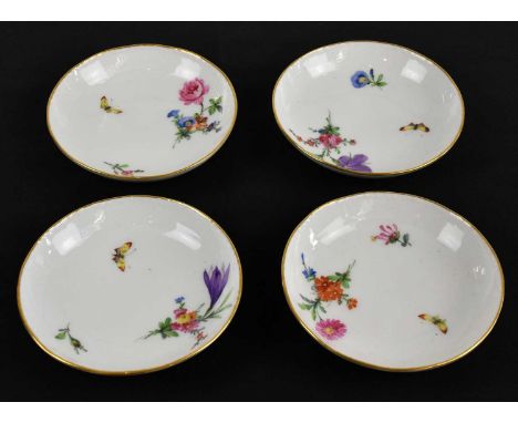 BERLIN KPM; a set of four porcelain saucers, decorated with floral sprigs and an insect against a moulded border, printed and