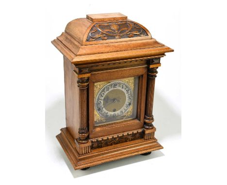 A German Art Nouveau carved walnut cased mantel clock, the brass face set with silvered chapter ring bearing Arabic numerals,