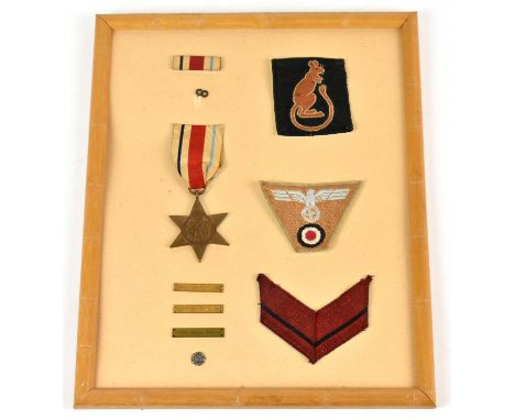 A framed and mounted medal and insignia collection comprising an Africa Star, a Desert Rat badge, a German EM NCO'S trapezoid