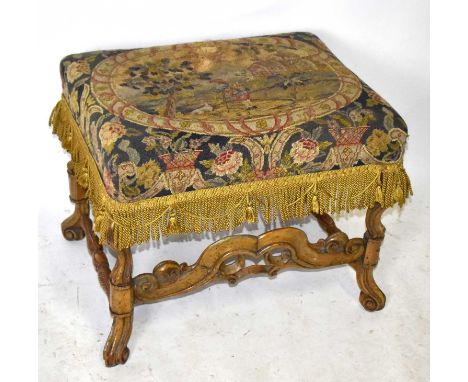 A Flemish walnut stool with tapestry seat decorated with figure and dog by his side in landscape setting, on scrolling feet, 