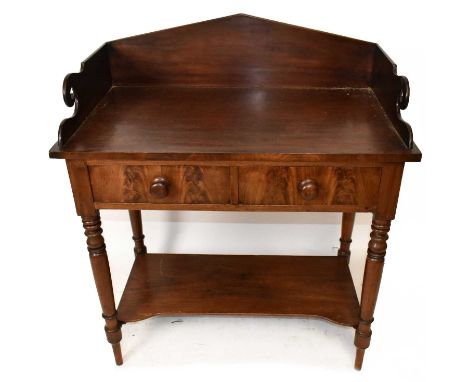 A Victorian mahogany wash stand with raised galleried back above two drawers and undertier shelf, on turned column supports, 