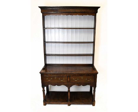 An 18th century style oak dresser, the raised back with three shelves and off white painted panelling, above two drawers and 