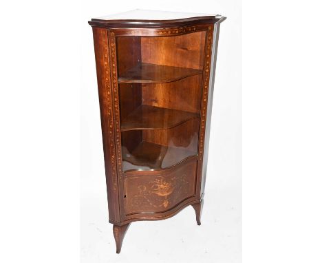 An Edwardian mahogany and floral inlaid serpentine freestanding corner cupboard with glazed upper section and panelled lower 