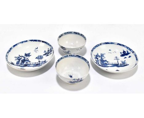 A pair of 18th century English blue and white porcelain tea bowls and saucers, each decorated with a house and fenced garden 