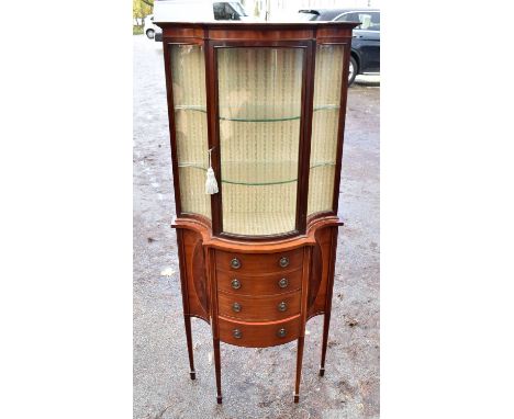 An Edwardian mahogany serpentine display cabinet, with glazed door, above four drawers, height 152cmCondition Report: Minor a