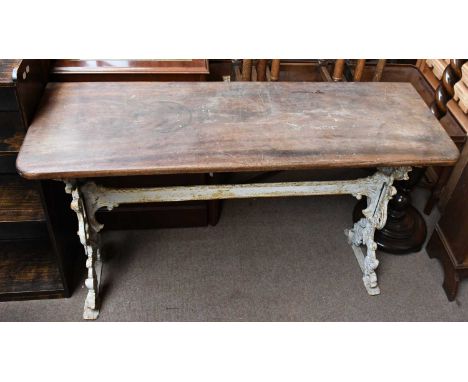 A Coalbrookdale style cast iron garden table, with hardwood top on pierced iron stand, decorated with scrolls, height 74cm, l