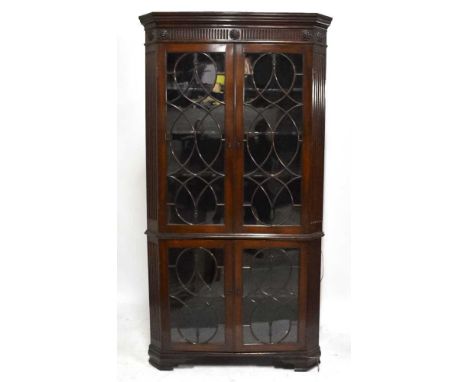 A George III mahogany freestanding corner cabinet, with moulded cornice above two pairs of astragal glazed doors, on ogee bra