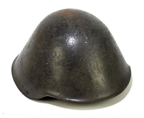 A post World War II East German army helmet with liner and chin strap.