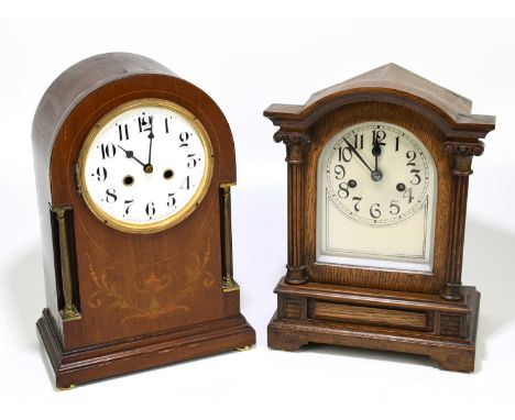 A late 19th century German oak cased dome topped mantel clock, the silvered dial set with Arabic numerals flanked by Corinthi