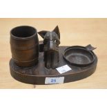 An early 20th Century carved wooden novelty desk stand or smoker's companion, the centre modelled