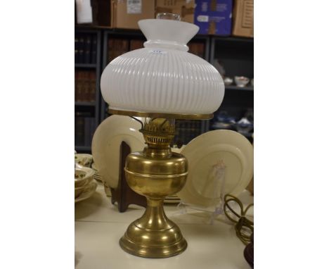 A late 19th Century brass oil lamp with a white glass shade and chimney, measuring 50cm high