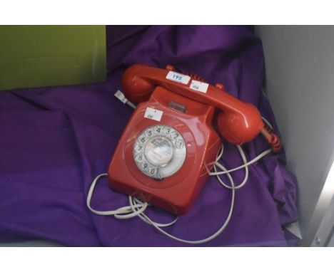 A vintage Kirkcaldy rotary telephone in ruby red.