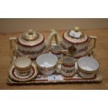 An early 20th Century Gemma crested porcelain miniature tea set, hand decorated with a red banded