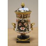 A Royal Crown Derby porcelain urn with cover, in the Traditional Imari pattern, measuring 17cm high