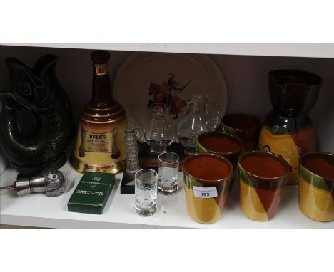 Shelf of collectables includes whisky jug and glass set on wooden plinth, gurgling jug etc. 