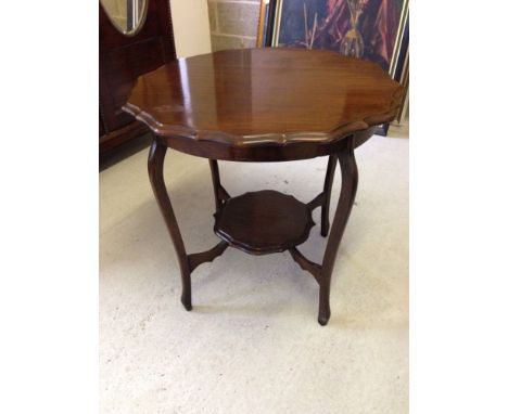 An Edwardian mahogany centre table with centre bracket shelf.