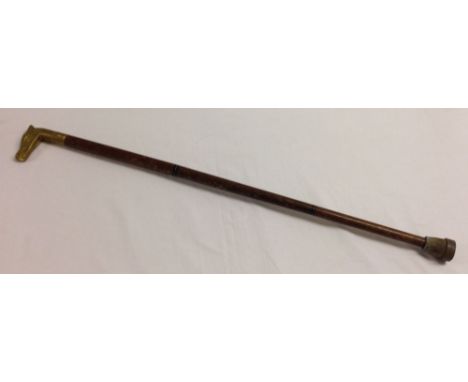 A vintage walking stick with brass horses head handle and concealed glass flask.