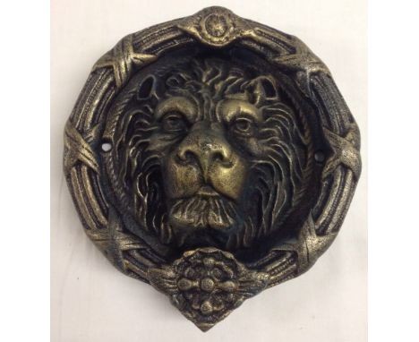 A large cast iron lion head door knocker 22cm diameter.