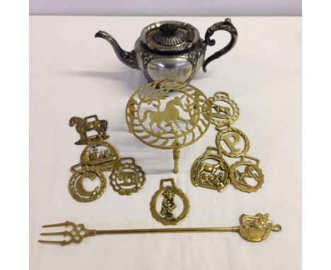 A silver plated teapot, horse brasses, brass trivet with horse decoration and a brass toasting fork.