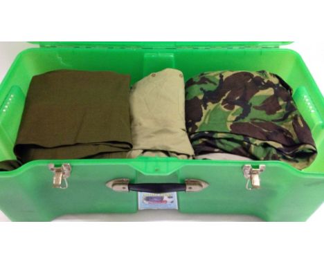 A green trunk containing a quantity of military trousers and shirts.