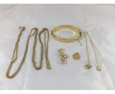 A collection of jewellery to include a gold plated bangle, a 9 carat gold and seed pearl set brooch in the form of a plant, a