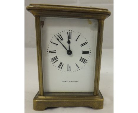 A brass carriage clock with Roman numerals to the dial, marked beneath "Made in France"