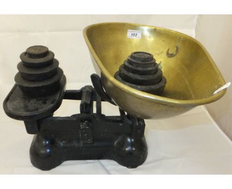 An iron set of weighing scales with brass bowl and a selection of graduated weights